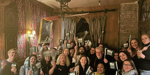 People smiling and holding green NUJ flags in a celebratory fashion.