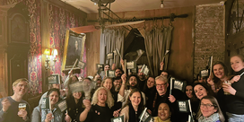 People smiling and holding green NUJ flags in a celebratory fashion.