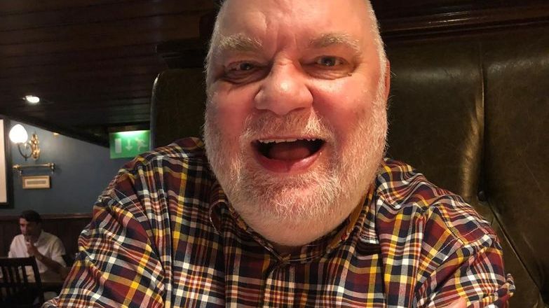 Andy Collier wearing a checked shirt and smiling.