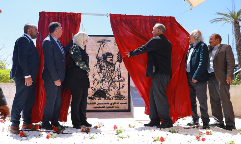 Attendees at the unveiling event are photographed looking at the new memorial. 