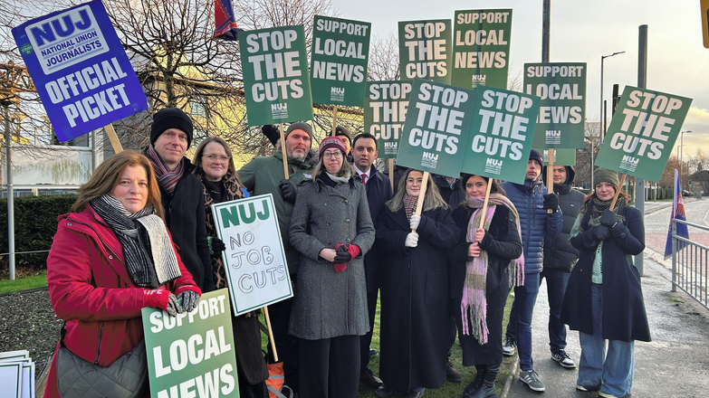 NUJ members stand on a picket line outside STV Glasgow HQ holding green 'Stop The Cuts' and 'Support Local News' placards.