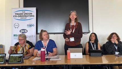 Five trade unionists behind a desk as part of a panel.