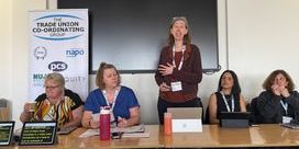 Five trade unionists behind a desk as part of a panel.
