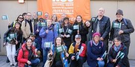 NUJ members pose behind an orange union banner outside parliament.