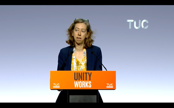 Laura Davison speaking behind an orange lectern with the slogan 'Unity Works' at the 2026 TUC Congress.