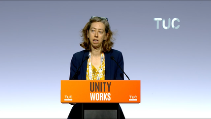 Laura Davison speaking behind an orange lectern with the slogan 'Unity Works' at the 2026 TUC Congress.