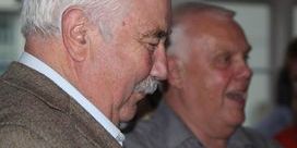Barry Fitzpatrick, wearing a patterned blazer, looks down while smiling.