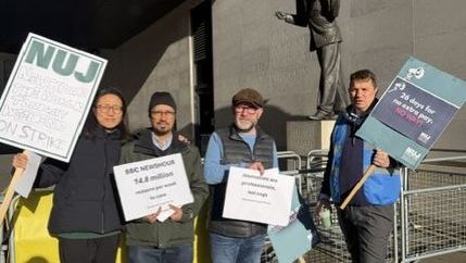Four NUJ members hold signs on the picket line outside Broadcasting House