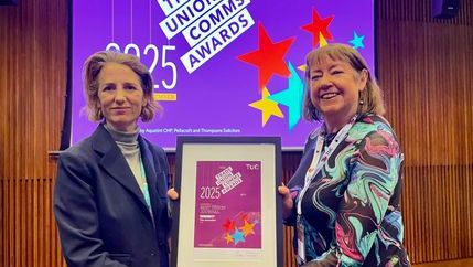Kate Bell (left) and Christine Buckley (right) hold a plaque in front of a purple 'Trade Union Comms Awards' banner.