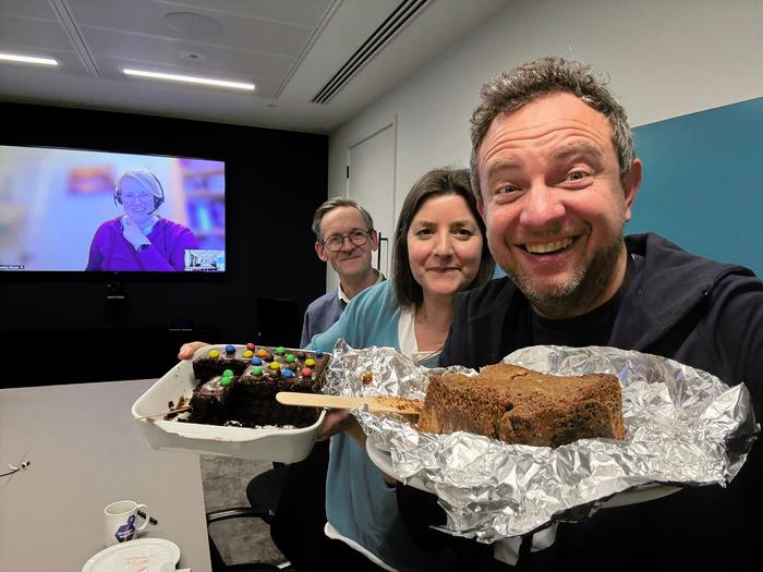 PA chapel reps holding cake in a meeting room.