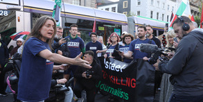 Journalists wearing blue 'Press' t-shirts stand in front of a banner that reads 'Israel, Stop Killing
journalists' in central Dublin.