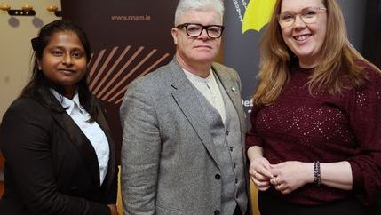 Three people stand in from of an NUJ banner wearing blazers.