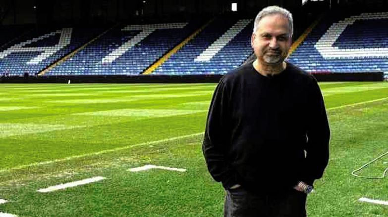 Barnie Choudhury standing in the Oldham FC stadium.