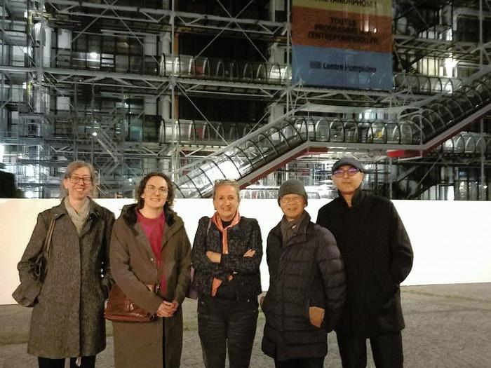 Members of the union's delegation and NUJ Paris branch stand outside the Pompidou Centre at night.